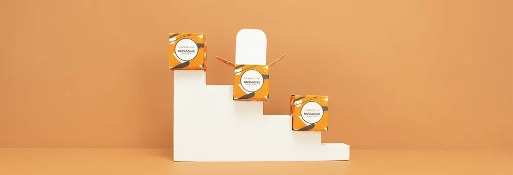 Drei Faltschachteln orange auf Treppe Drei Faltschachteln orange auf Treppe